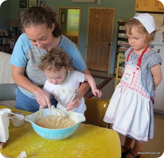 Mary is helping cousin Jennifer make blueberry muffins while "Nurse Nancy" stands by watching